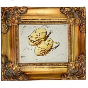 May include: A framed vintage-style print of the Libra constellation depicted as a set of golden scales. The artwork features celestial lines, star markings, and the text LIBRA, PL 22. The frame is ornate, metallic gold with decorative corner carvings.
