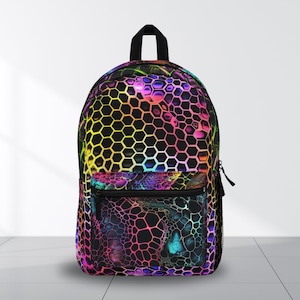 May include: A black backpack with a vibrant, multicoloured honeycomb pattern. The design features shades of pink, purple, yellow, and green. The backpack has a front pocket with a zip and a black handle.