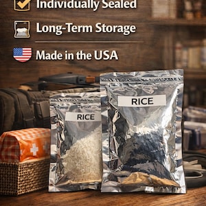 May include: Two silver pouches labeled "RICE" filled with white and brown rice, set against a wooden background. The image includes text that reads "READY ANYTIME", "Individually Sealed", "Long-Term Storage", and "Made in the USA". The bottom text says "STAY PREPARED".