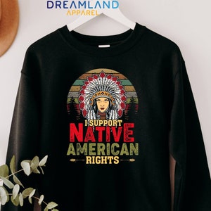 May include: Black sweatshirt with a vintage-style graphic of a Native American woman wearing a headdress. The graphic includes the text "I Support Native American Rights".