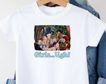 May include: White t-shirt with a graphic print of a group of people from the TV show 'The Brady Bunch' and the text 'Girls... Ugh!'