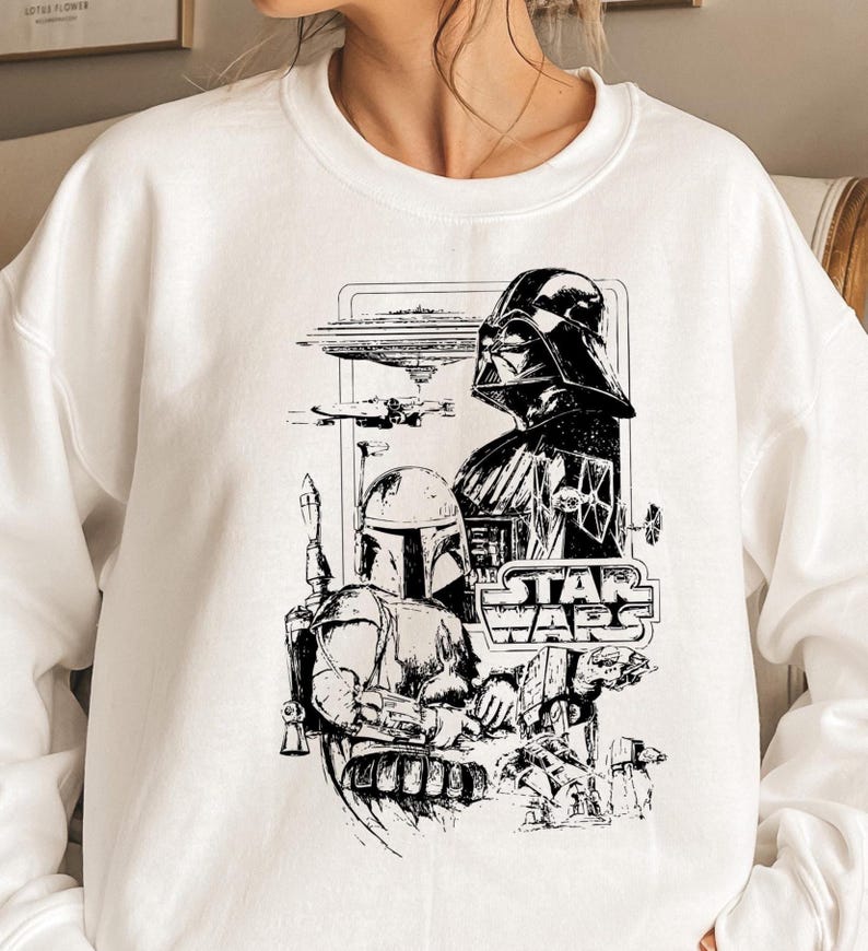May include: White crewneck sweatshirt featuring a black and white Star Wars graphic. The design includes Darth Vader, Boba Fett, and the Star Wars logo, with various spacecraft and characters.
