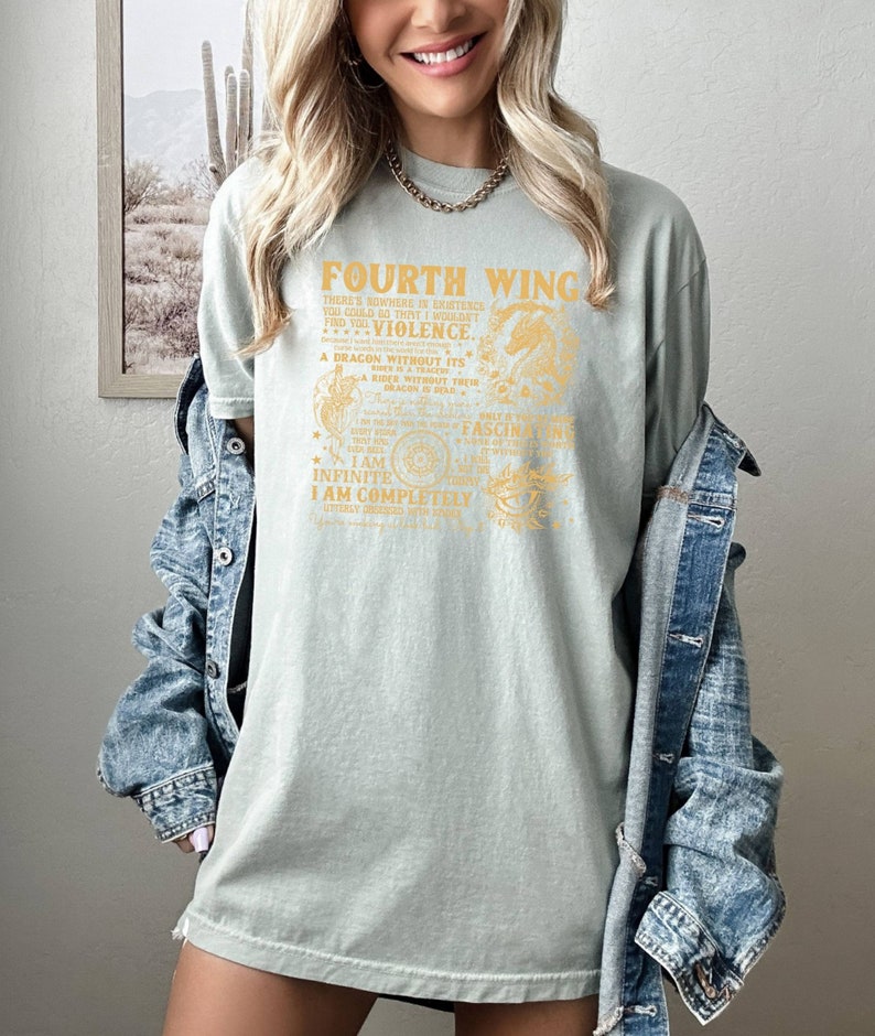 May include: A light green t-shirt with a gold graphic print that reads "Fourth Wing" and includes a dragon and other imagery. The text on the shirt reads "There's nowhere in existence you could go that I wouldn't find you...Violence. A dragon without its rider is a tracer. A rider without their dragon is a ghost. I am infinite. I am completely utterly obsessed with you."