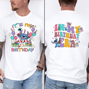 Puede incluir: Camiseta blanca con un personaje de dibujos animados azul sosteniendo un pastel y el texto "It's my birthday" en la parte delantera. La parte posterior de la camiseta tiene el texto "In my birthday era" con un personaje de dibujos animados azul sosteniendo una botella.