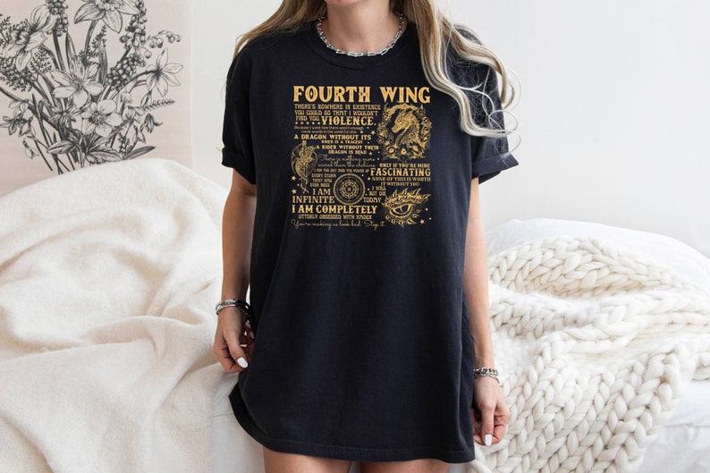 May include: Black t-shirt with a gold graphic print that reads "Fourth Wing" and includes a dragon design. The text includes the words "I am Infinite, I am Completely, Fascinating, Violence, Dragon without its Fire".