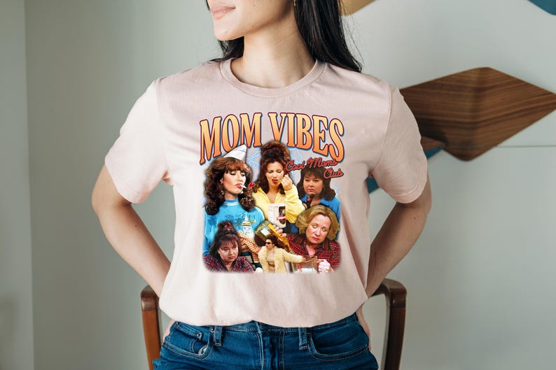 Puede incluir: Una camiseta rosa con un estampado gr&aacute;fico de un grupo de mujeres con el texto "Mom Vibes Cool Moms Club".