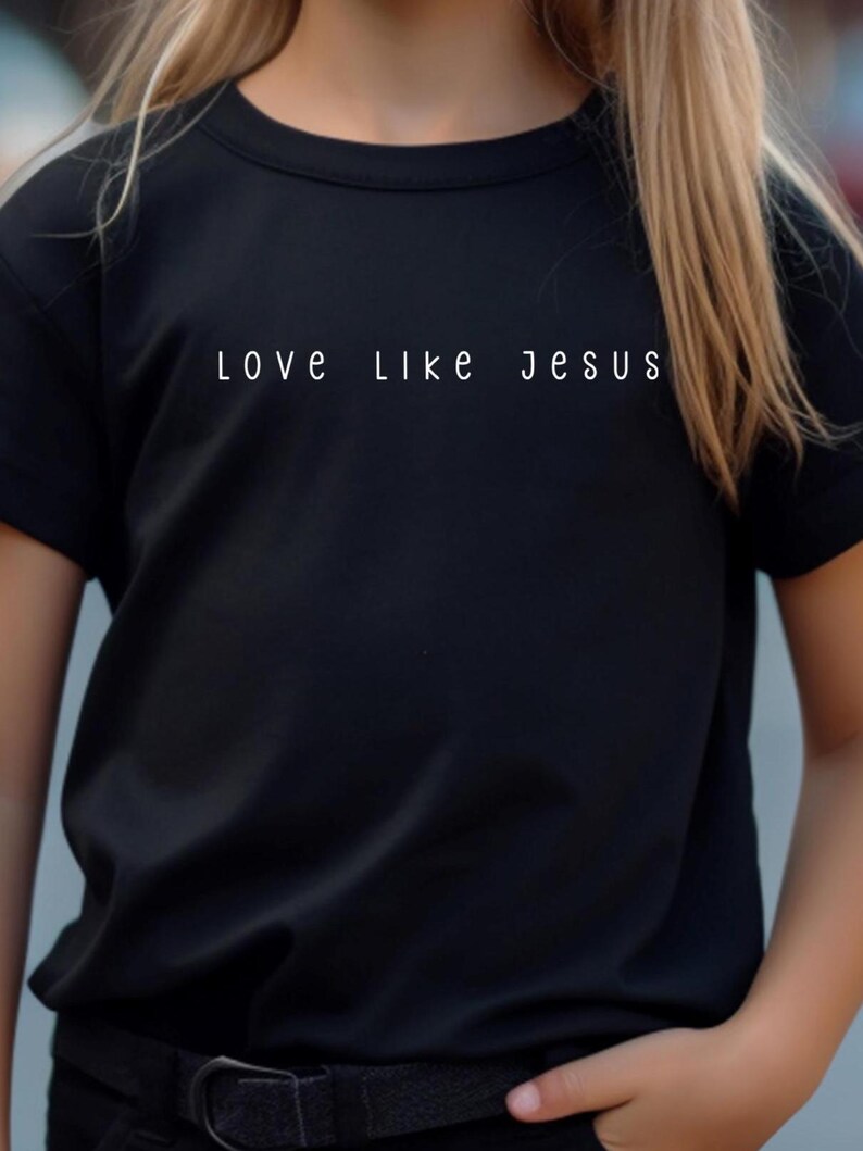 May include: Black crew neck t-shirt with the white text "LOVE LIKE JESUS" across the chest. The shirt is made of a soft material and is suitable for everyday wear.