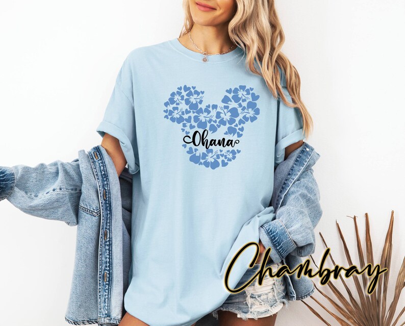 Puede incluir: Camiseta azul claro con una silueta de Mickey Mouse floral azul y la palabra "Ohana" en texto negro.
