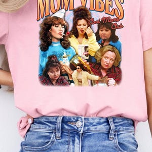 Puede incluir: Camiseta rosa con un gr&aacute;fico de un collage de mujeres con el texto "MOM VIBES Cool Moms Club".