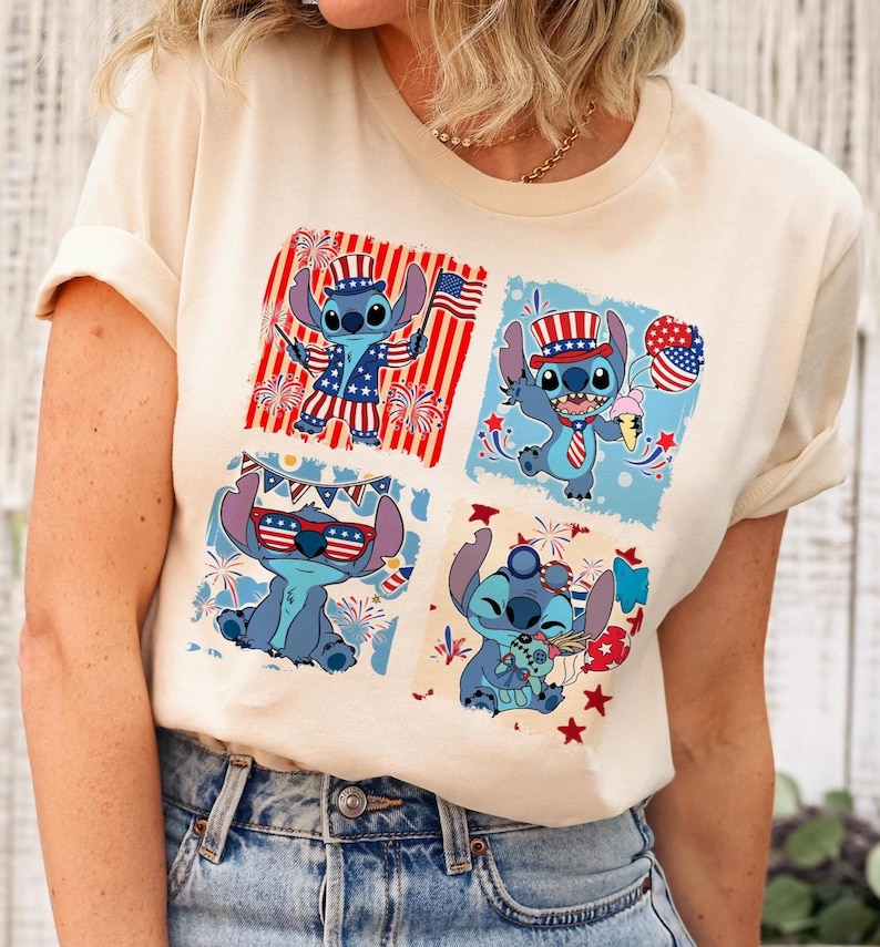 May include: Cream-colored t-shirt featuring a four-panel design of the character Stitch in patriotic attire. Each panel showcases Stitch with American flag elements, fireworks, and ice cream, celebrating Independence Day.