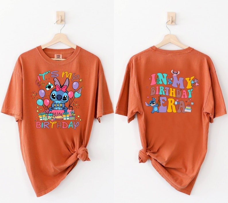 Puede incluir: Camiseta naranja con un personaje de dibujos animados de Stitch sosteniendo un pastel de cumplea&ntilde;os y globos. El texto "It's my birthday" est&aacute; impreso en la parte delantera de la camiseta. La parte posterior de la camiseta tiene el texto "In my birthday era" con un personaje de Stitch sosteniendo un pastel.