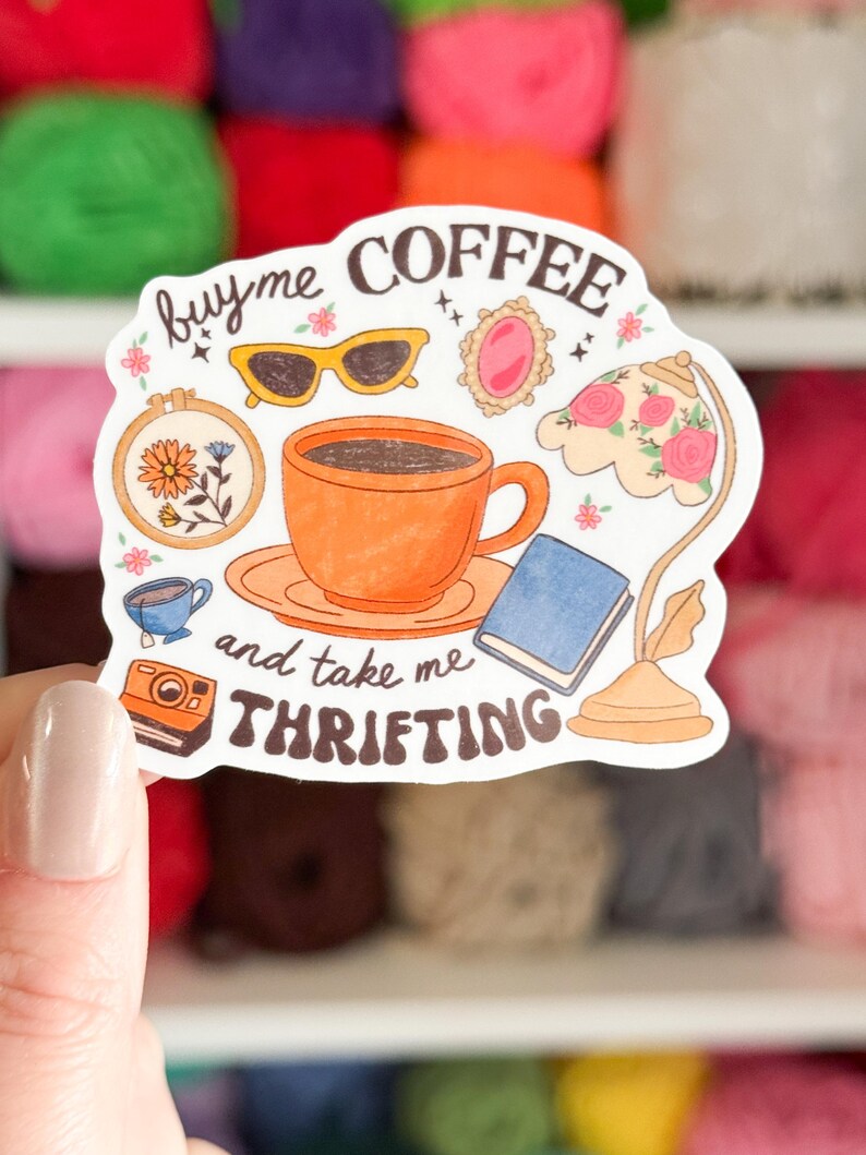Może przedstawiać: Naklejka z napisem "buy me coffee and take me thrifting" z ilustracjami filiżanki kawy, okular&oacute;w przeciwsłonecznych, aparatu fotograficznego, książki i lampy. Naklejka ma białe tło i r&oacute;żnorodne kolorowe ilustracje.