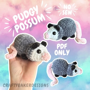 May include: Handmade crochet possum plushies in gray, white, black, and pink. The text "PUDGY POSSUM" and "NO SEW" are displayed. The text "PDF ONLY" and "CRAFTYBAKERDESIGNS" are also visible. These plushies are a unique handmade item.