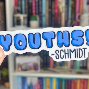 以下が含まれることがあります： 「YOUTHS! -SCHMIDT」と書いてある青い文字の白いステッカー。文字はバブルフォントです。