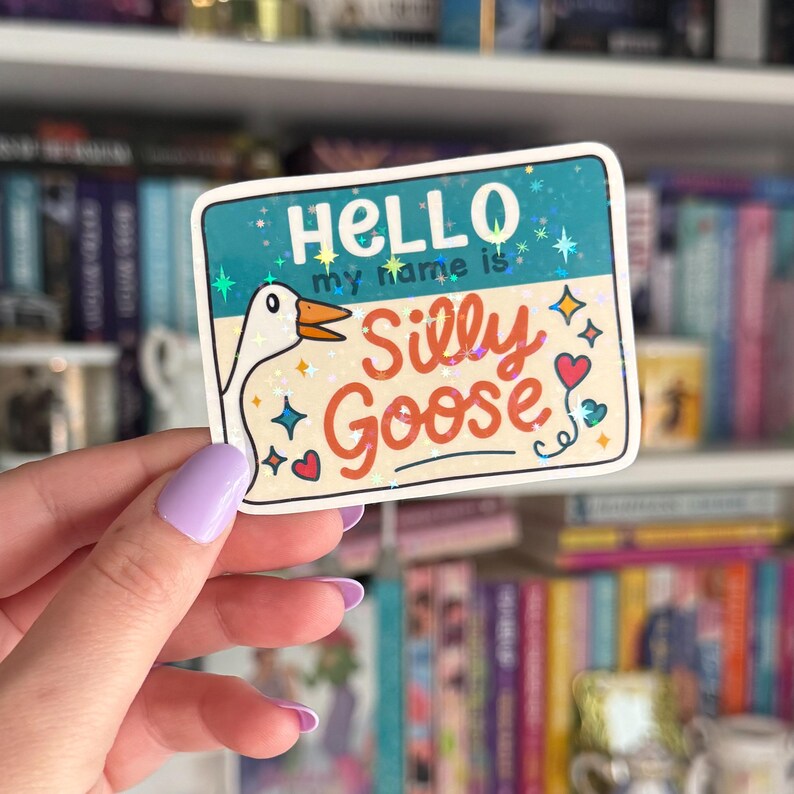 Op de afbeelding: Een sticker met een cartoon-gans en de tekst "Hello my name is Silly Goose". De sticker heeft een blauwe achtergrond met glitter en sterren.