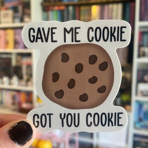 以下が含まれることがあります： 「Gave me cookie got you cookie」というテキストと、茶色のチョコレートチップクッキーのイラストが描かれた白いステッカーです。