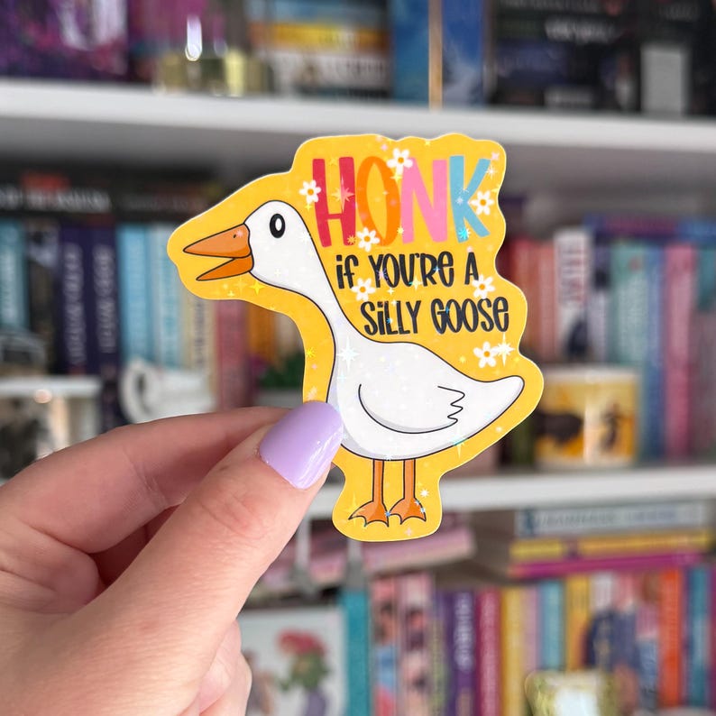 Op de afbeelding: Een gele sticker met een cartoon-gans en de tekst "Honk if you're a silly goose". De gans is wit met een roze snavel en gele poten. De sticker heeft een glinsterende afwerking.