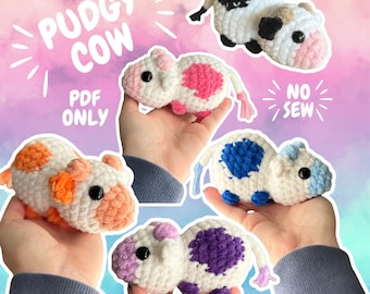 Op de afbeelding: Een verzameling handgemaakte gehaakte koeienknuffels in verschillende kleuren, waaronder wit met roze, oranje, blauwe, zwarte en paarse vlekken. De tekst "PUDGY COW" en "PDF ONLY" is zichtbaar. De knuffels worden in handen gehouden.