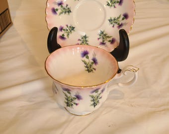 Royal Albert #4466. Porcelana fina rosa con cardos morados. Nunca usada. Sin astillas ni grietas.