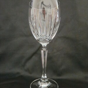 以下が含まれることがあります： 透明なガラス製のワイングラスで、背が高く細いステムと、広く丸いボウルが付いています。ボウルには、装飾的な縦のカットガラスの模様があります。
