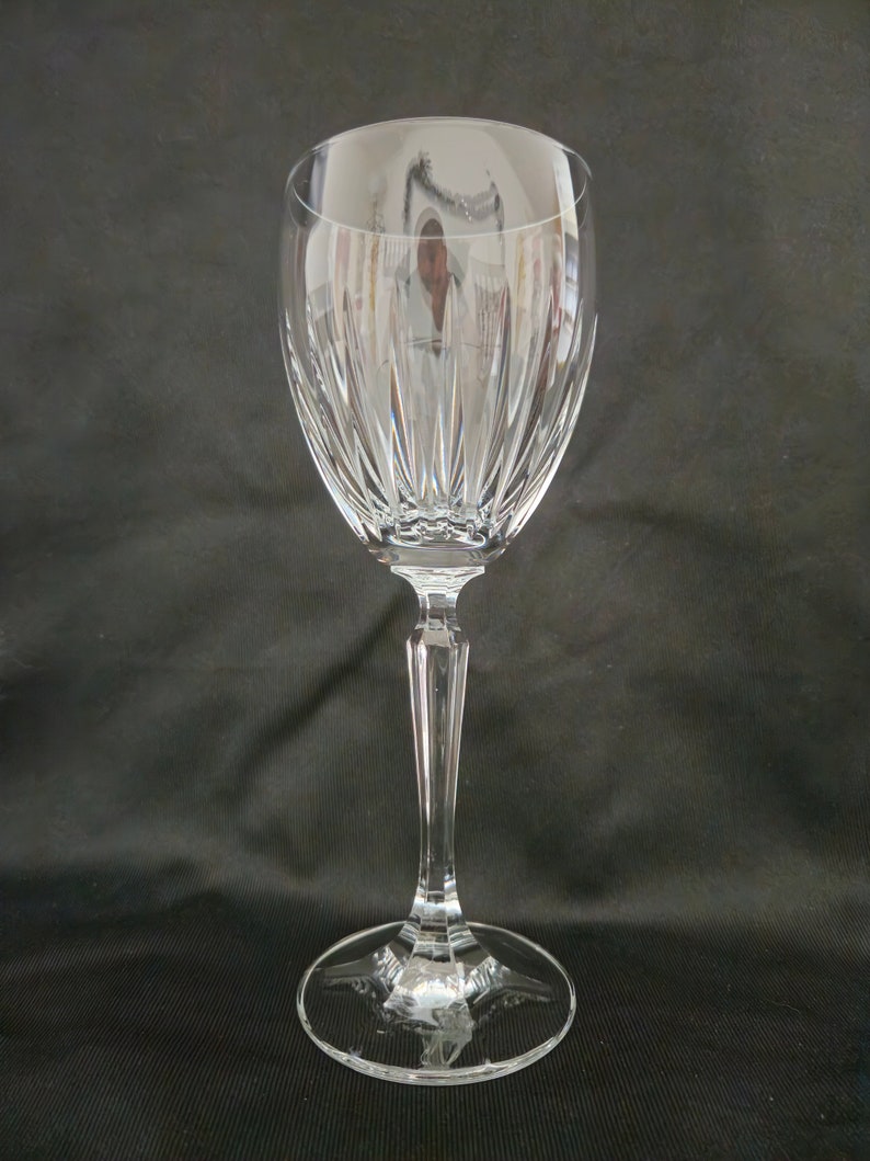 以下が含まれることがあります： 透明なガラス製のワイングラスで、背が高く細いステムと、広く丸いボウルが付いています。ボウルには、装飾的な縦のカットガラスの模様があります。