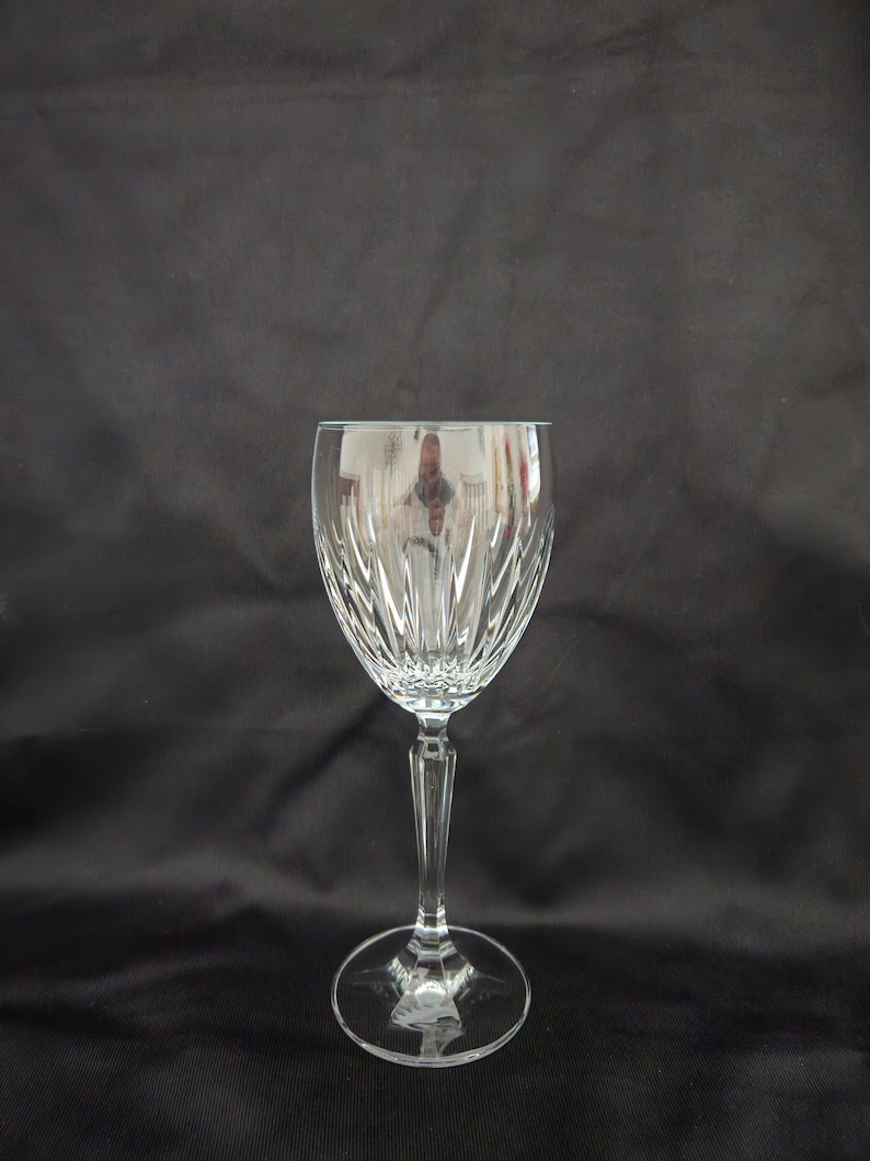 以下が含まれることがあります： カットクリスタルデザインの透明なガラス製のワイングラス。グラスは背の高いステムと丸いベースを持っています。