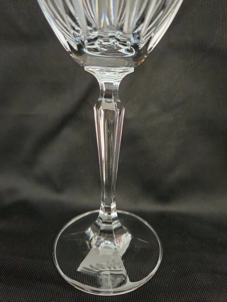 以下が含まれることがあります： 透明なガラス製のワイングラスで、背が高く細いステムと幅広で平らなベースがあります。グラスは装飾的なカットガラスのデザインです。