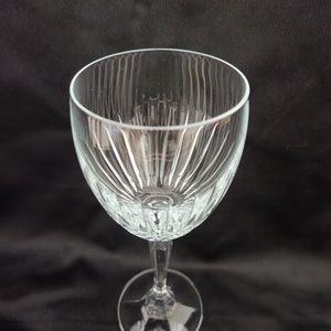 以下が含まれることがあります： フルーテッドデザインの透明なガラス製のワイングラス。グラスは背の高いステムと丸いベースを持っています。