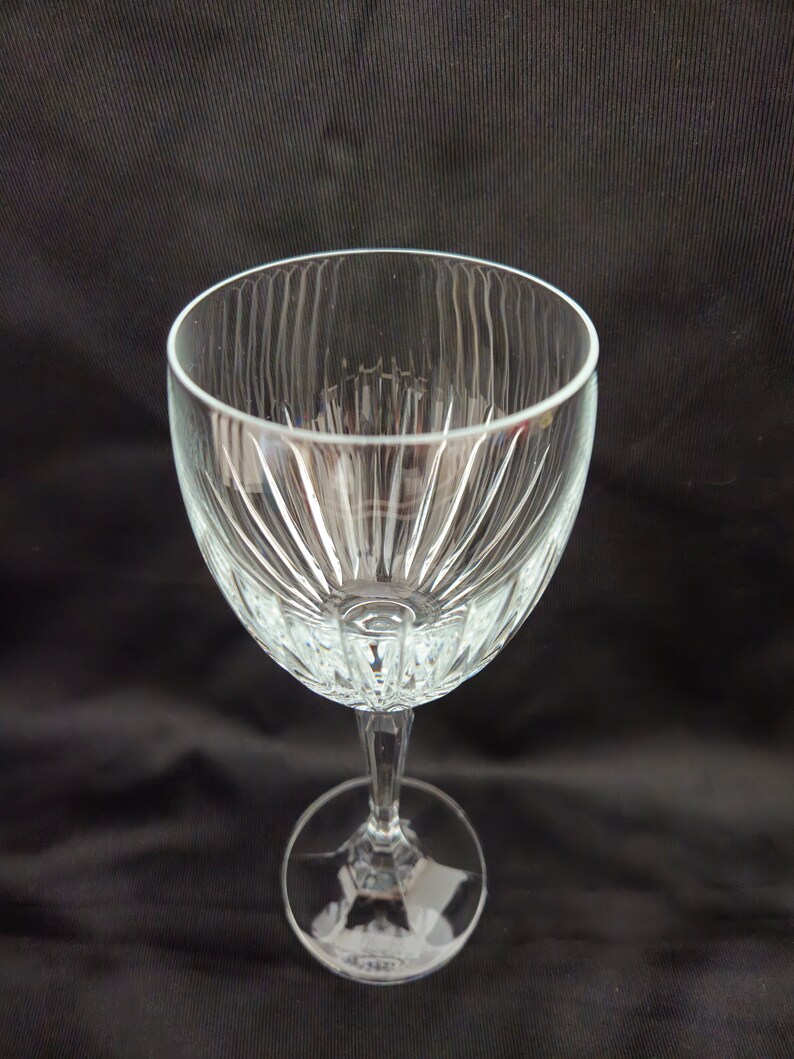 以下が含まれることがあります： フルーテッドデザインの透明なガラス製のワイングラス。グラスは背の高いステムと丸いベースを持っています。