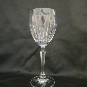 以下が含まれることがあります： 高い茎と広いボウルを持つ透明なガラス製のワイングラス。ボウルは、垂直な線でカットされたガラスのデザインが施されています。