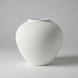 May include: A white, textured ceramic vase with a rounded body and a narrow neck. The vase has a speckled surface and a smooth, unglazed rim. The vase is a decorative item for the home.
