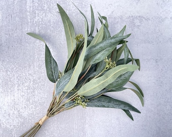 May include: A bunch of artificial eucalyptus stems with green leaves and small green flower buds.