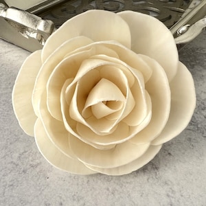 May include: A single, cream-colored, wooden rose with multiple layers of petals.