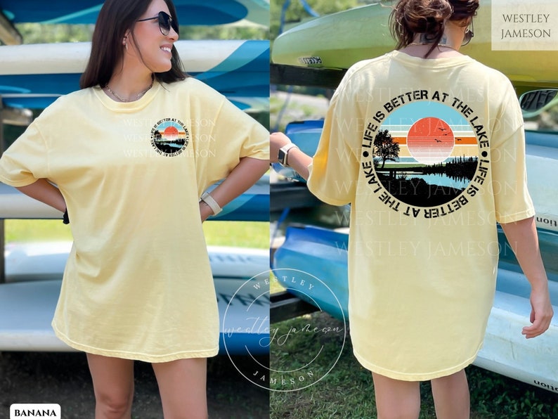 May include: A yellow t-shirt with a graphic print of a sunset over a lake. The text "Life is better at the lake" is printed around the graphic. The text "Westley Jameson" is printed on the back of the shirt.