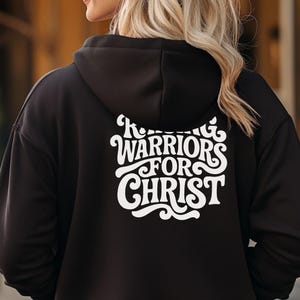 May include: Black hoodie with a white graphic on the back that says "KING WARRIORS FOR CHRIST" in a retro font.