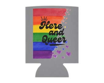 May include: A grey can cooler featuring a rainbow design and the text "Here and Queer". The rainbow is made of watercolour-like stripes and there are small purple hearts scattered around the design.