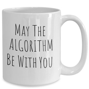 May include: White ceramic coffee mug with black text that reads "May the Algorithm Be With You".