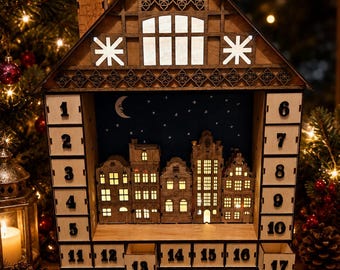 May include: A wooden house-shaped advent calendar with twenty-four numbered drawers. The center features a miniature illuminated cityscape against a dark blue night sky with a crescent moon and stars. The structure has a peaked roof and windows.
