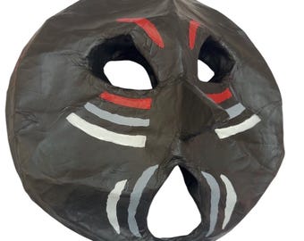 Máscara decorativa redonda negra y roja hecha a mano