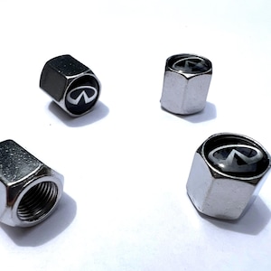 May include: Four silver-colored tire valve stem caps with the Infiniti logo in black and silver. The caps are hexagonal and have a threaded interior for secure attachment to the tire valve stem.