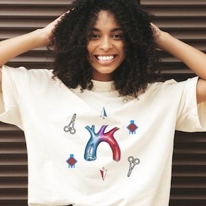 Könnte beinhalten: Weißes T-Shirt mit einem Grafikdruck eines stilisierten menschlichen Herzens mit einem Kompass und chirurgischen Scheren drumherum. Das Herz ist rot und blau mit einem blauen Pfeil, der nach Norden zeigt, und einem roten Pfeil, der nach Süden zeigt.