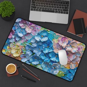 May include: A colorful mousepad with a floral design featuring blue, pink, yellow, and green flowers. The flowers are painted in a textured style, giving the mousepad a unique and artistic look.