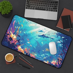 May include: A colorful mousepad with a vibrant underwater scene featuring coral reefs, fish, and dolphins. The mousepad has a blue, green, and purple color scheme with a white mouse on top.