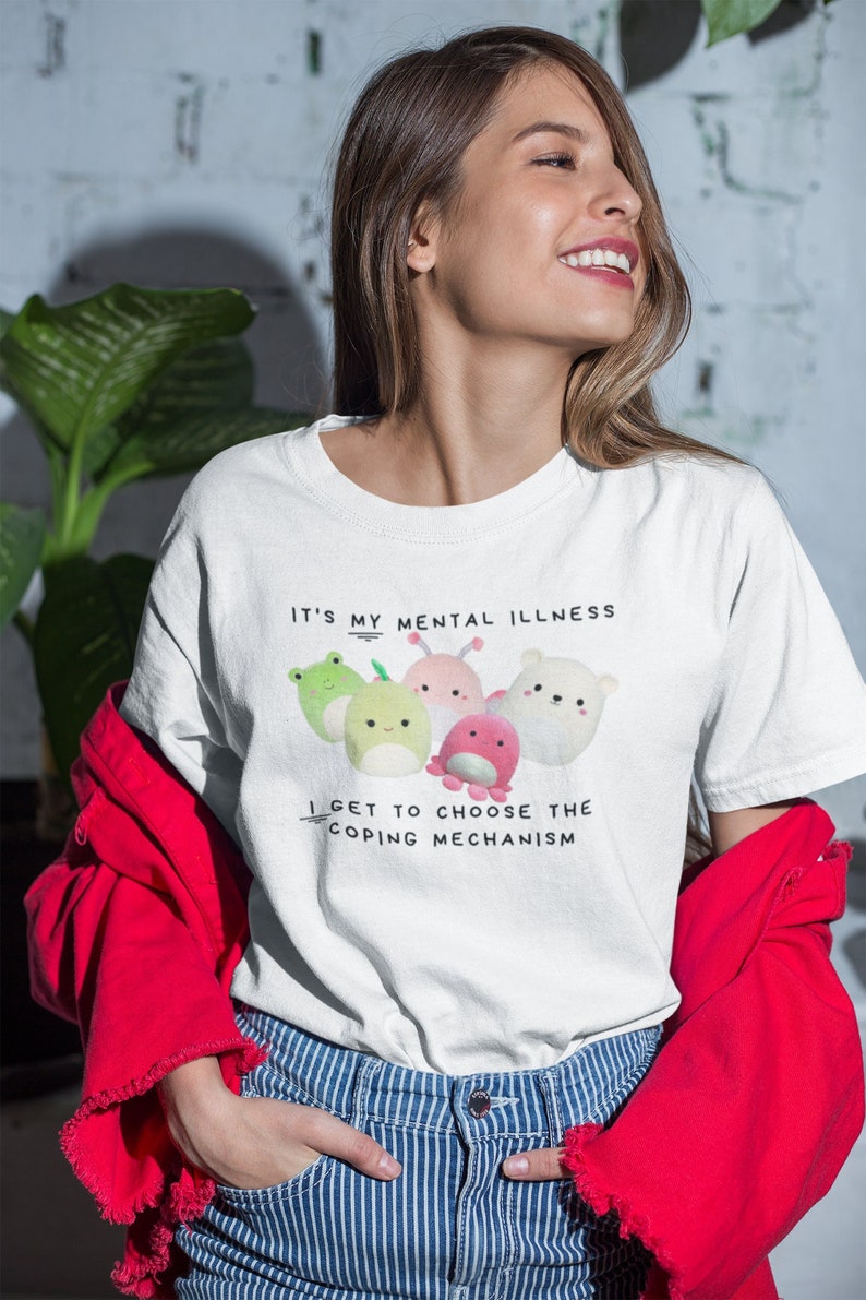 Może przedstawiać: Biała koszulka z grafiką kolorowych postaci z kresk&oacute;wek i tekstem "It's my mental illness I get to choose the coping mechanism."
