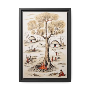May include: Framed artwork depicting a village scene with a large tree, huts, and figures in red clothing. A fire burns at the base of the tree. The artwork is framed in a black rectangular frame.