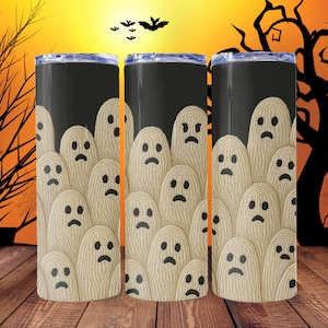 Könnte beinhalten: Drei schwarze Becher mit Halloween-Motiv. Die Becher zeigen ein Design aus beigen Geistern mit traurigen Gesichtern vor einem schwarzen Hintergrund. Der Hintergrund umfasst einen Sonnenuntergang, Fledermäuse und einen gruseligen Baum.