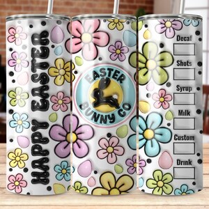 Puede incluir: Un vaso de acero inoxidable blanco con un estampado floral colorido y el texto "Happy Easter Easter Bunny Co." El vaso tiene una tapa negra y una pajita.