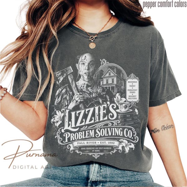 May include: A charcoal gray short-sleeve t-shirt featuring a white graphic print of a person holding an axe, a house, and a teacup. The text reads Lizzie's Problem Solving Co., Fall River, Est. 1892, and lists household family persistent issues.