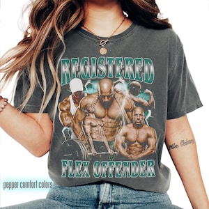 Peut inclure: T-shirt gris foncé avec un motif d'hommes musclés et le texte "REGISTERED FLEX OFFENDER" dans un design vert et blanc. Le t-shirt a un aspect vintage et vieilli et les mots "pepper comfort colors" sont imprimés en bas.