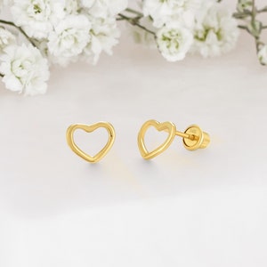 May include: A pair of gold heart-shaped stud earrings. The earrings are made of a thin, delicate wire and have a simple, elegant design.